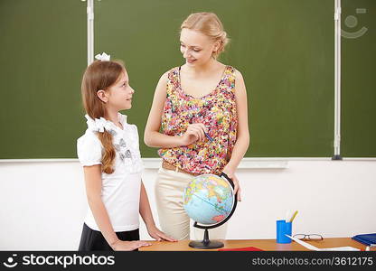 Little girl with a teacher studying at school class