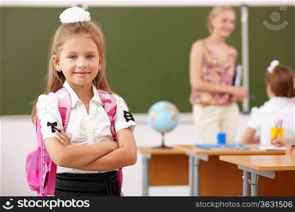 Little girl with a teacher studying at school class