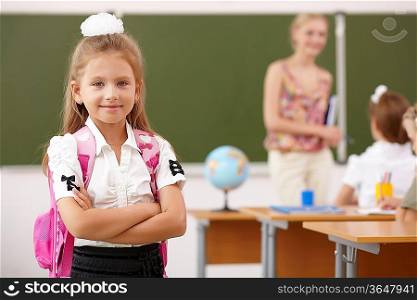 Little girl with a teacher studying at school class