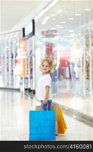 Little girl with bags in the store