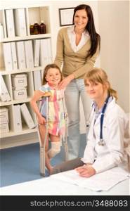 Little girl with bandaged leg standing with crutches mother assistance