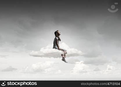 Little girl with bear. Cute girl wearing pajamas with toy bear in hand sitting on cloud