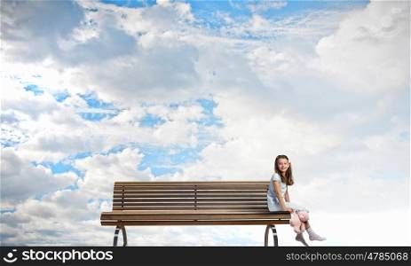 Little girl with bear. Cute girl wearing pajamas with toy bear in hand sitting on bench