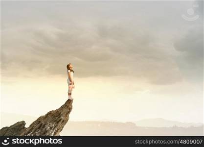 Little girl with bear. Cute girl wearing pajamas with toy bear in hand standing on rock edge