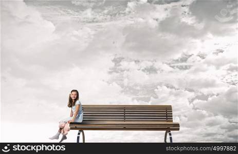 Little girl with bear. Cute girl wearing pajamas with toy bear in hand sitting on bench