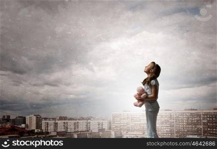 Little girl with bear. Cute girl wearing pajamas with toy bear in hand