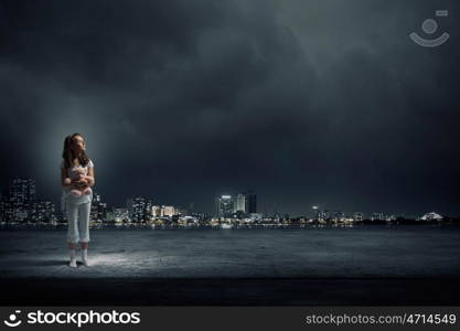 Little girl with bear. Cute girl wearing pajamas with toy bear in hand