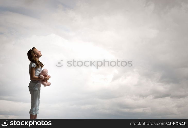 Little girl with bear. Cute girl wearing pajamas with toy bear in hand