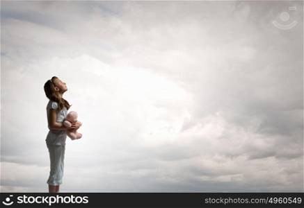 Little girl with bear. Cute girl wearing pajamas with toy bear in hand