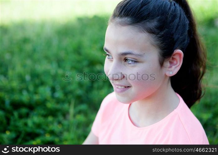 Little girl with blue eyes sitting at the garden