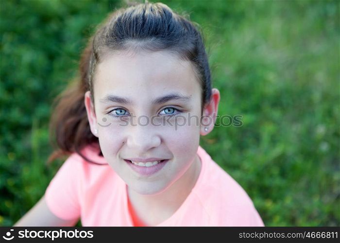 Little girl with blue eyes sitting at the garden