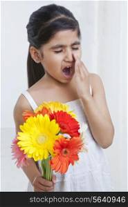 Little girl with flowers about to sneeze