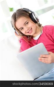 Little girl with headphones and electronic tablet