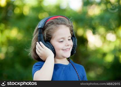 Little girl with headphones on a park