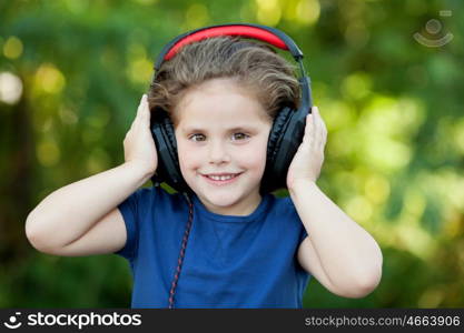 Little girl with headphones on a park