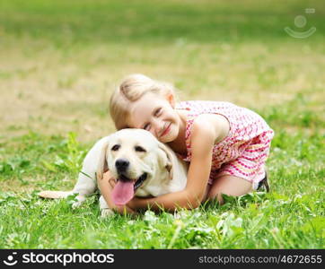 little girl with her dog. A little blond girl with her pet dog outdooors in park