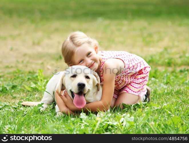 little girl with her dog. A little blond girl with her pet dog outdooors in park