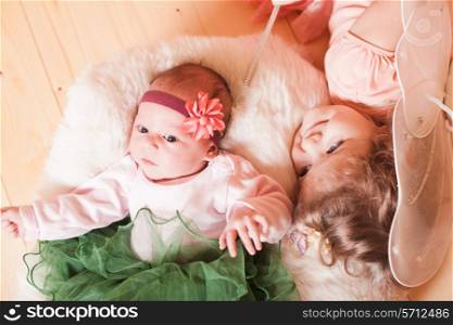 Little girl with her newborn sister in a basket