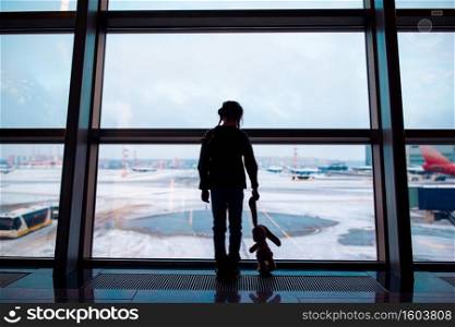 Little girl with her rabbit toy in airport near big window while wait for boarding. Little girl in airport near big window while wait for boarding