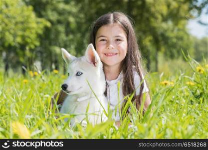 Little girl with husky puppy. Little smiling girl with husky puppy in park