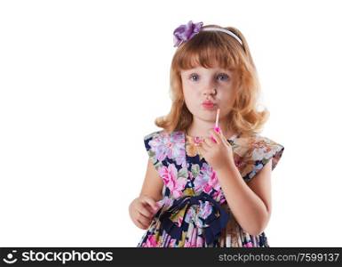 little girl with lipstick in hand in dress with flowers on white background