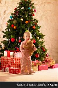Little girl with parcels round Christmas tree