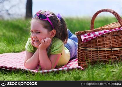 Little girl with picnic basket at lawn