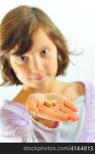 little girl with pills in hand
