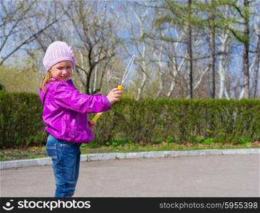 Little girl with soap bubbles at park