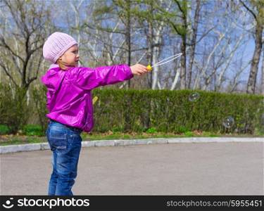 Little girl with soap bubbles at park