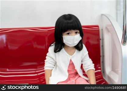 Little girl with surgical mask face protection flu and Virus outbreak in public transportation  skytrain or subway . Concept of New normal lifestyle, Using public transport to travel to school.