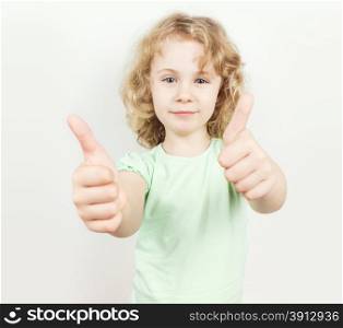 Little girl with thumbs up on white background