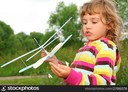 little girl with toy airplane in hands outdoor