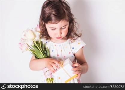 Little girl with tulips and box with present for mom