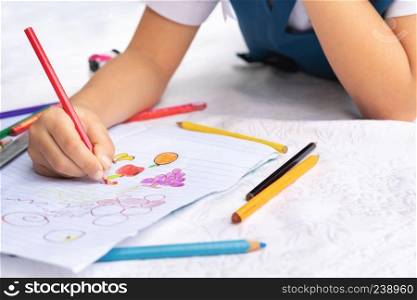 little girl writes to writing-books. The decision of lessons. girl lay down drawing the picture