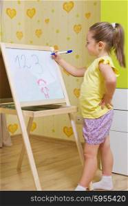 Little girl writing on the whiteboard