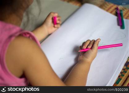 little girl written practice on white notebook. subject is blurred.