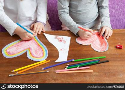 Little Girls are Drawing Red and Colorful Hearts for Mothers Day or Fathers Day or Valentines Day. Birthday