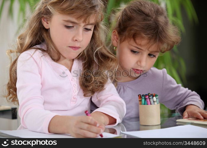 Little girls drawing with crayons