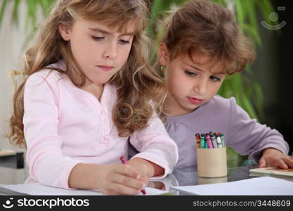 Little girls drawing with crayons