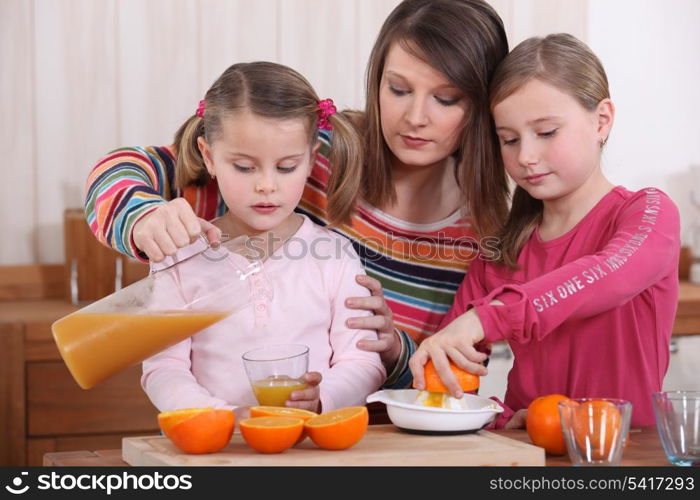 Little girls making orange juice