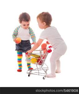 Little girls play with shopping trolley and doll. Grocery store playing