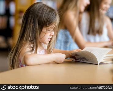 Little girls reading books in library. I love reading