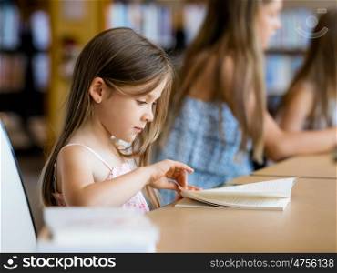Little girls reading books in library. I love reading