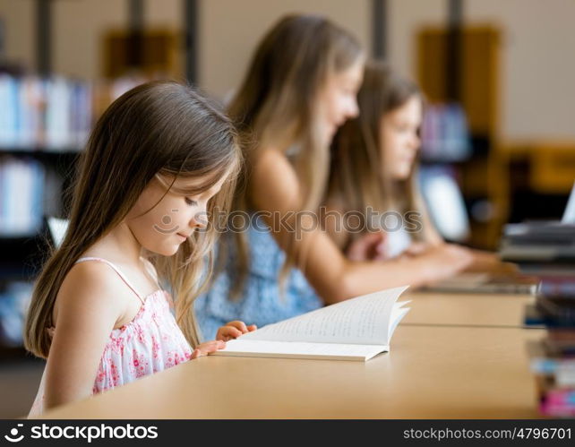 Little girls reading books in library. I love reading