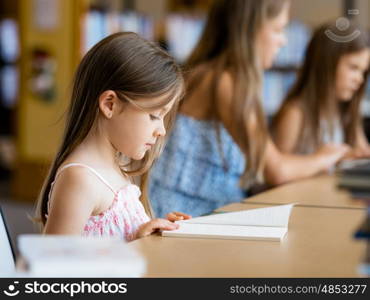 Little girls reading books in library. I love reading