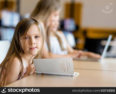 Little girls reading books in library. I love reading