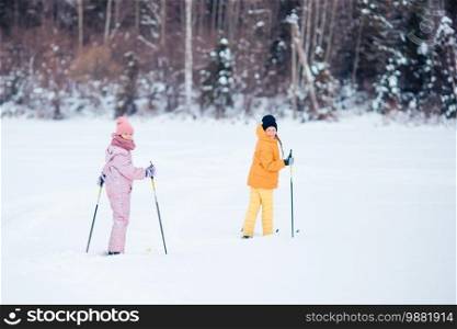 Little girls skiing in the mountains together. Winter sport for kids.. Child skiing in the mountains. Winter sport for kids.