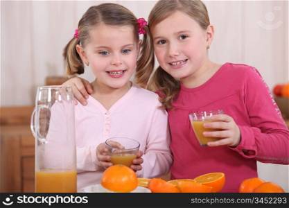Little girls squeezing oranges
