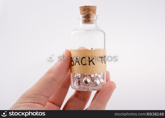 Little glass bottle in hand on a white background